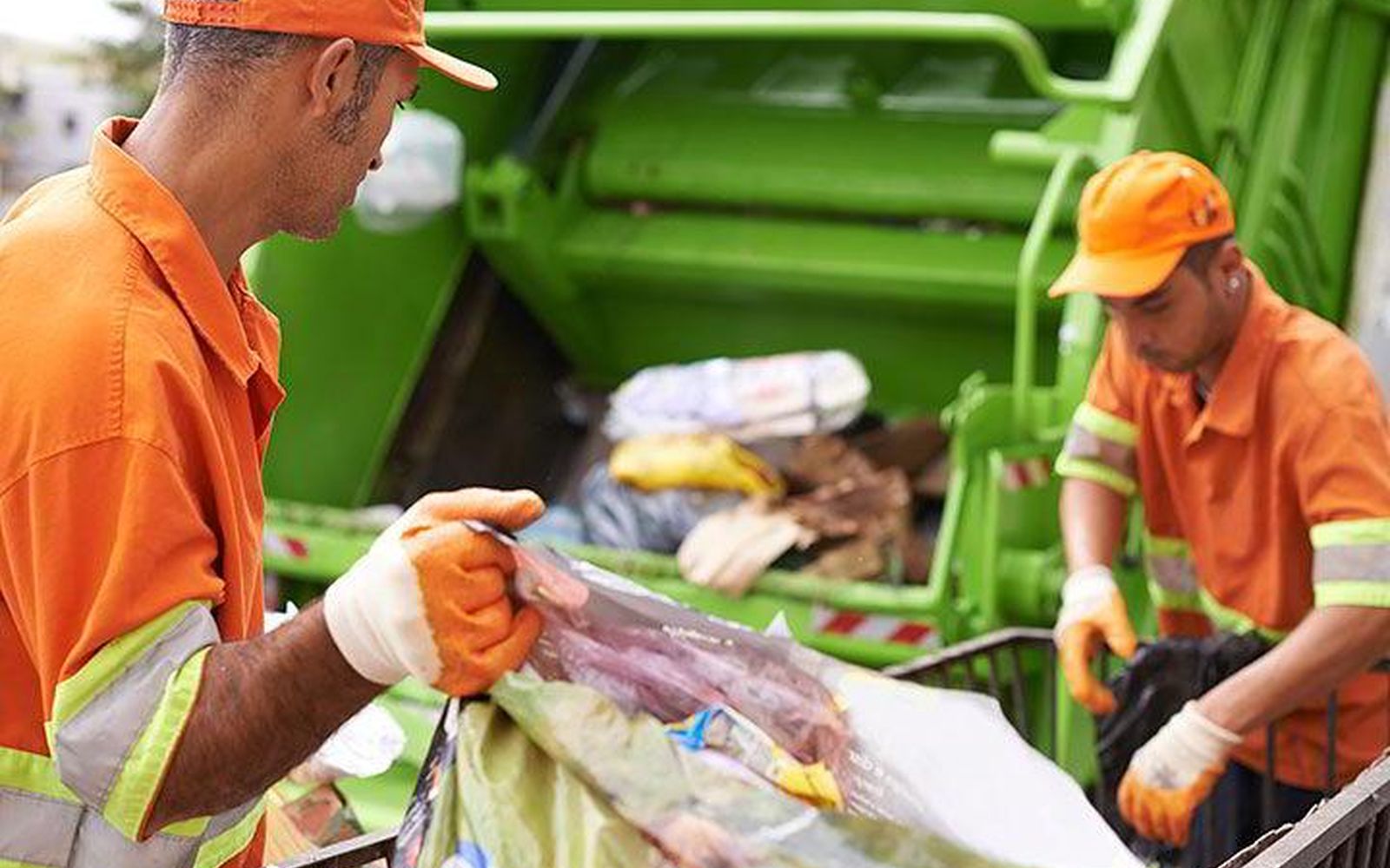 Operarios de recolección separando residuos junto a la unidad